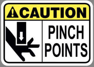 graphic of a piece of metal striking a hand with a caution sign sharing that there is a pinch point