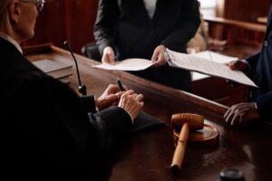 Judge reviewing documents with attorneys in a courtroom during a patent litigation expert witness proceeding.